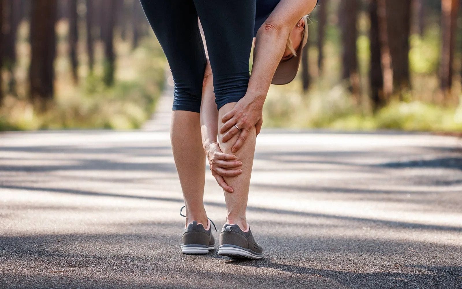Woman jogging with muscle cramp
